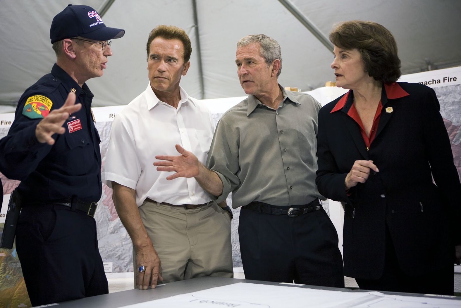 A fire official briefs California Gov. Arnold Schwarzenegger, President George W. Bush and Feinstein at Kit Carson Park after touring a neighborhood of destroyed homes in the Rancho Bernardo area of San Diego in 2007.