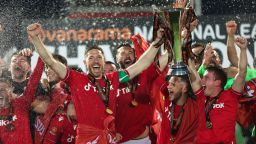 WREXHAM, WALES - APRIL 22: Ben Tozer and Luke Young of Wrexham lift the Vanarama National League Trophy as Wrexham celebrate promotion back to the English Football League during the Vanarama National League match between Wrexham and Boreham Wood at Racecourse Ground on April 22, 2023 in Wrexham, Wales. (Photo by Matthew Ashton - AMA/Getty Images)
