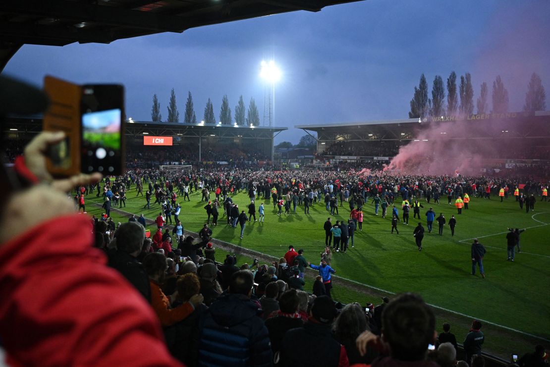 Wrexham's fans celebrate on the pitch after the club won the title. 