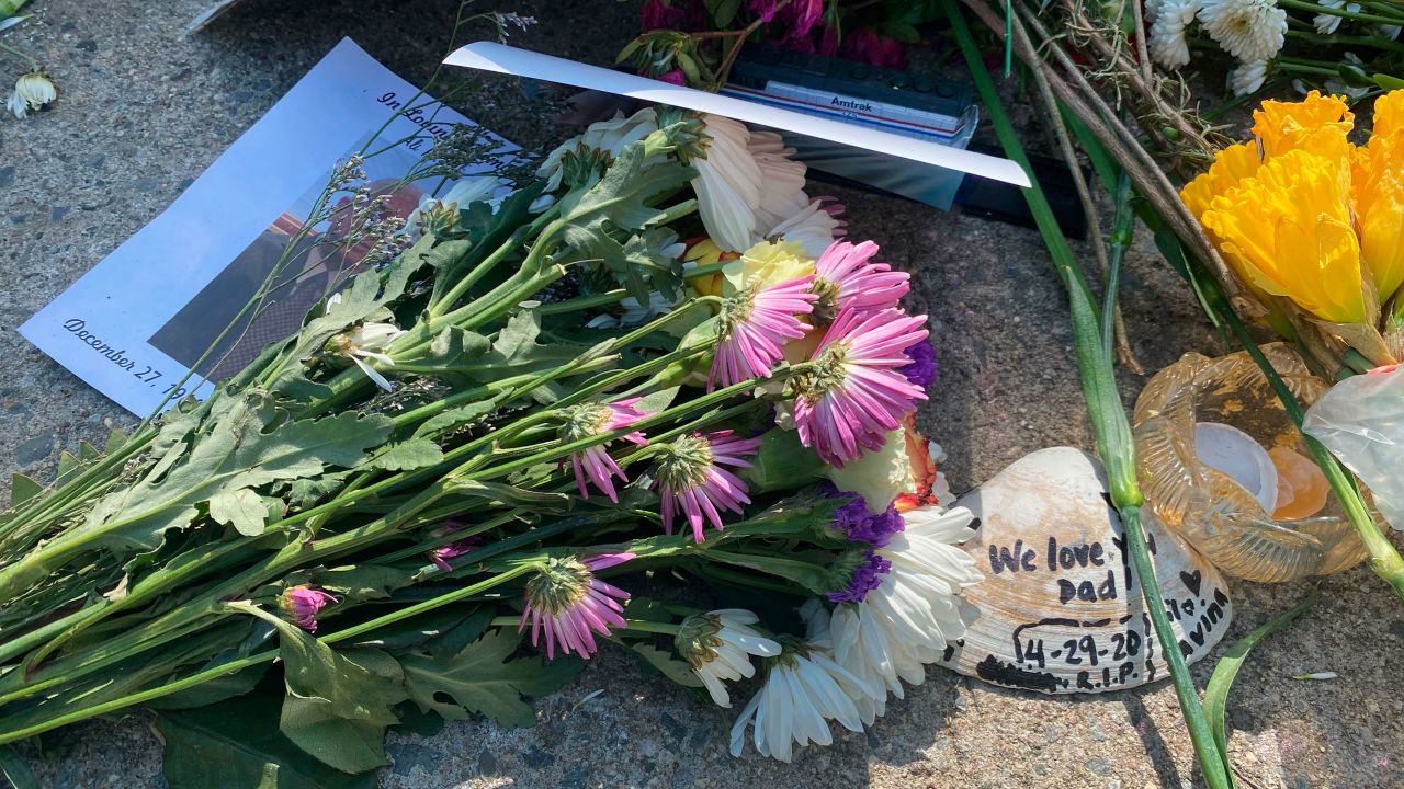 Flowers and photos are left at a memorial for Queens Covid Remembrance Day in Queens, New York, on May 2, 2021.