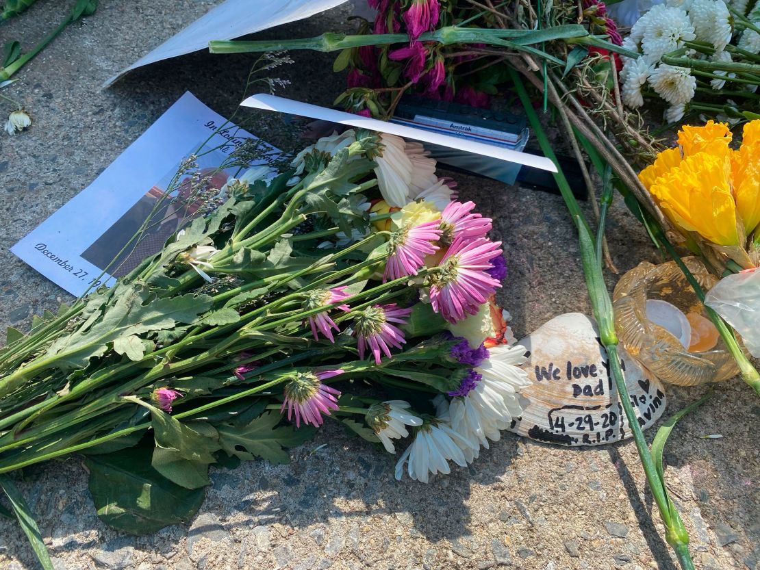 Flowers and photos are left at a memorial for Queens Covid Remembrance Day in Queens, New York, on May 2, 2021.