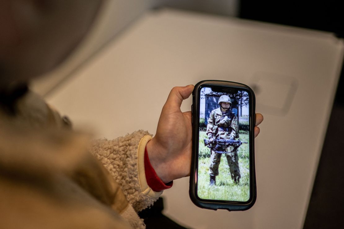 Rina Gonoi, a former member of Japan's Ground Self-Defense Force, checks old photos on her phone.