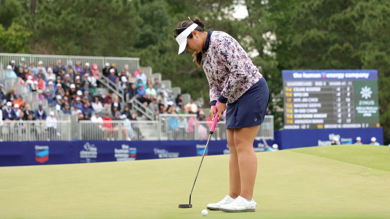 Woo putts on the 18th green.