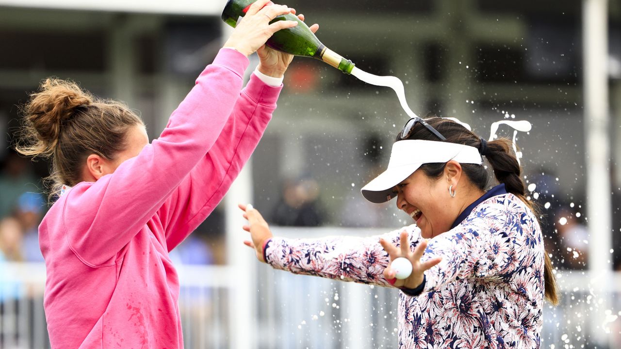 After winning, Wu is splashed with champagne.