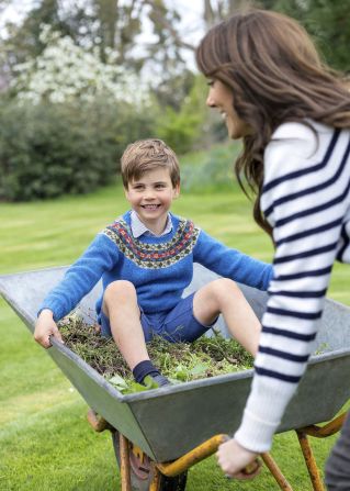 Prince Louis is pushed in a wheelbarrow by his mother in Windsor, England, in April 2023. The photo was released by Kensington Palace to mark Louis' fifth birthday.