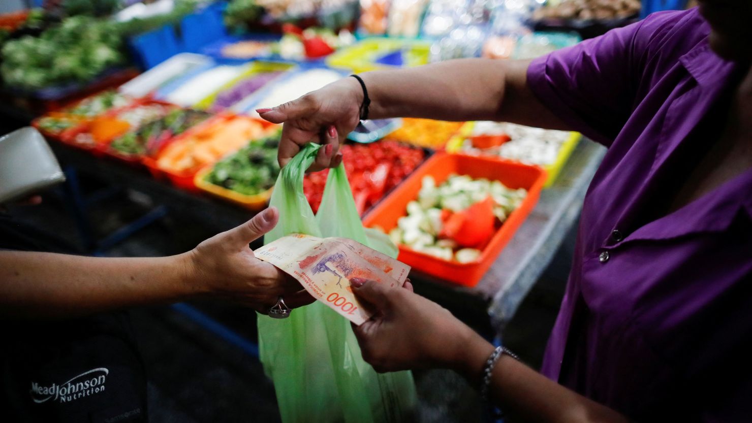 A costumer pays at a greengrocery store in a local market, as Argentina's annual inflation rate tore past 100% in February, the country's statistics agency said on Tuesday, the first time it has hit triple figures since a period of hyperinflation in 1991, over three decades ago, in Buenos Aires, Argentina March 14, 2023. REUTERS/Agustin Marcarian