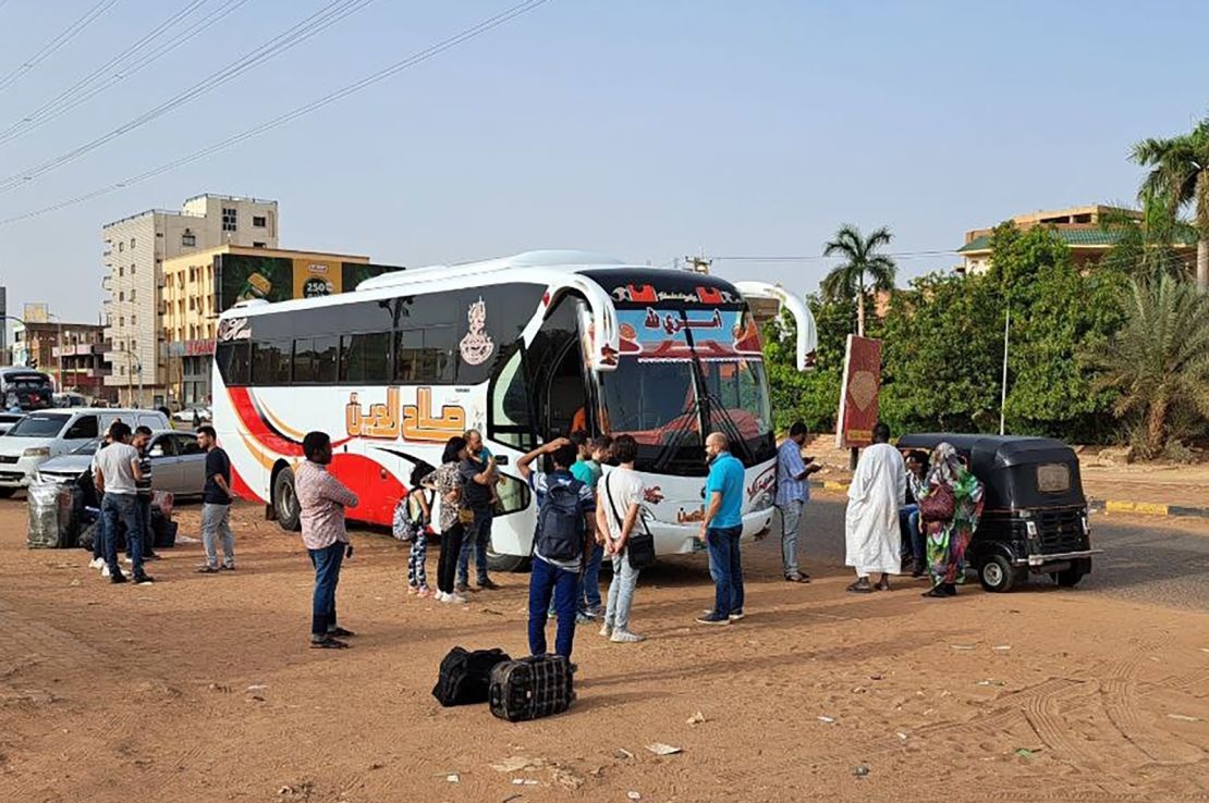 People wait to board a bus on Tuesday in Sudan's capital, Khartoum, where intense fighting between army and paramilitary forces has prompted an exodus of civilians fleeing to Egypt. 