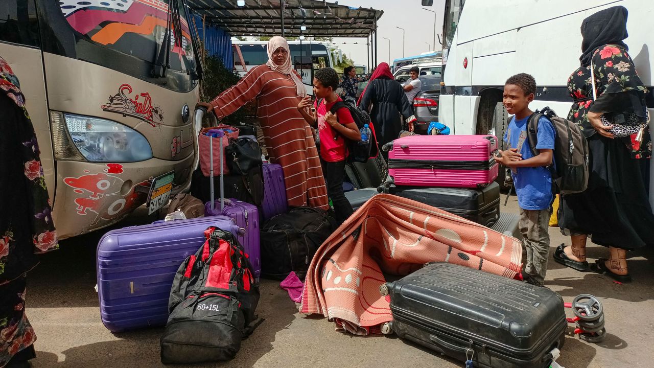Passengers fleeing war-torn Sudan disembark at a bus station near the Egyptian city of Aswan, on April 25, 2023.