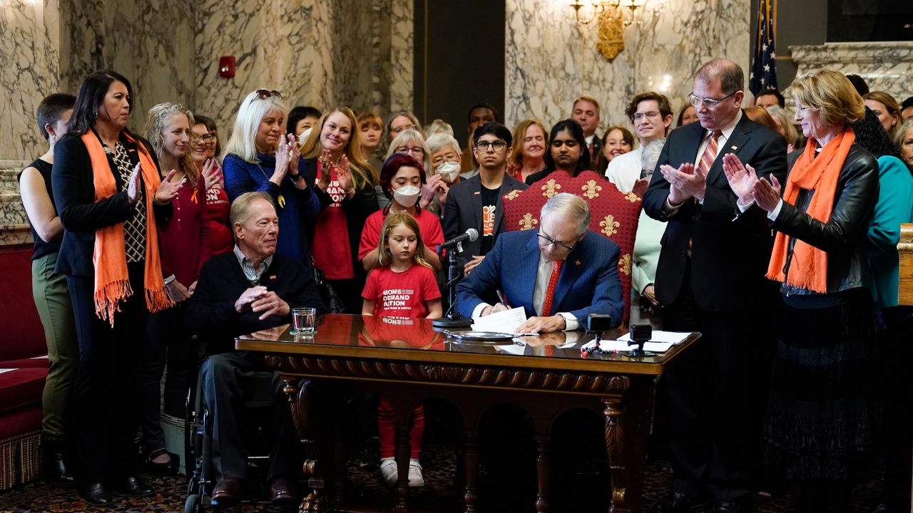 Washington Gov. Jay Inslee signs House Bill 1240, which prohibits the manufacture, importation, distribution and sale of  assault-style weapons in the state, on Tuesday in Olympia, Washington. 