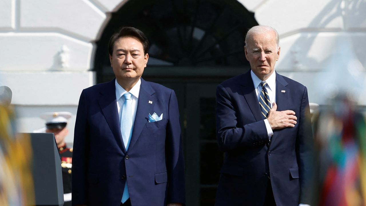President Joe Biden and South Korea's President Yoon Suk Yeol listen to their countries' national anthems together during an official White House State Arrival Ceremony on the South Lawn of the White House in Washington, DC, on April 26. 