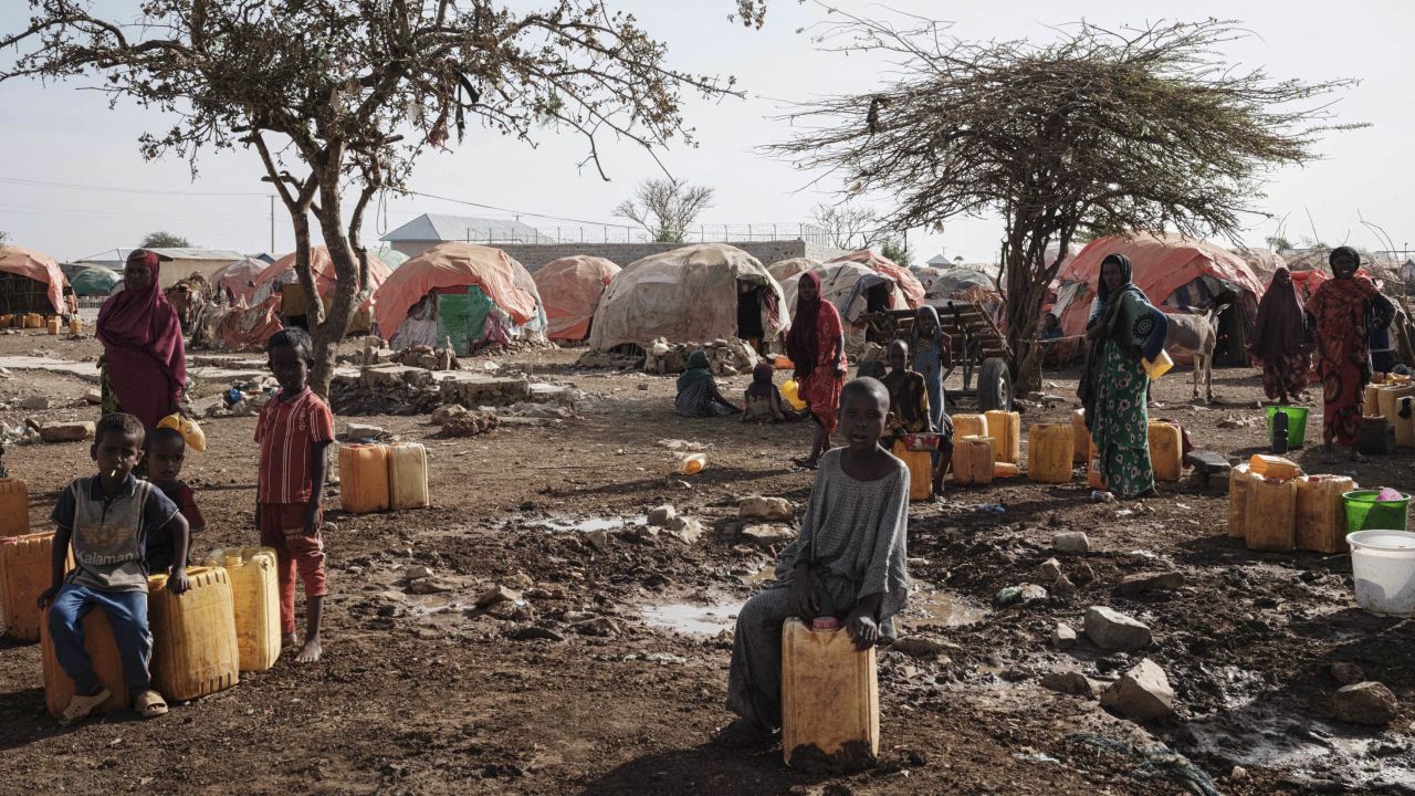 People wait for water at a camp in Baidoa, Somalia, on February 13, 2022. 