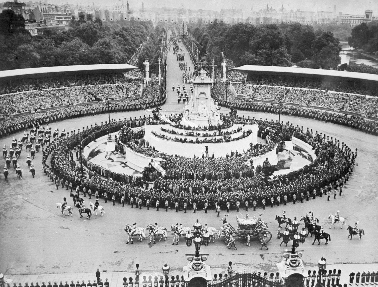 The Queen's carriage passes by the Victoria Memorial in front of Buckingham Palace.
