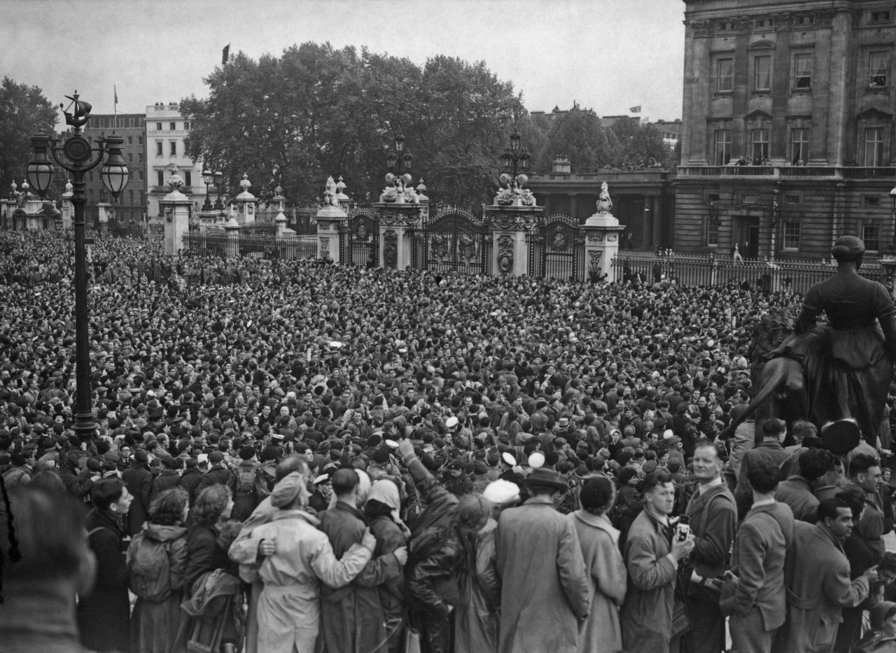 A crowd outside Buckingham Palace cheers for the royal family.