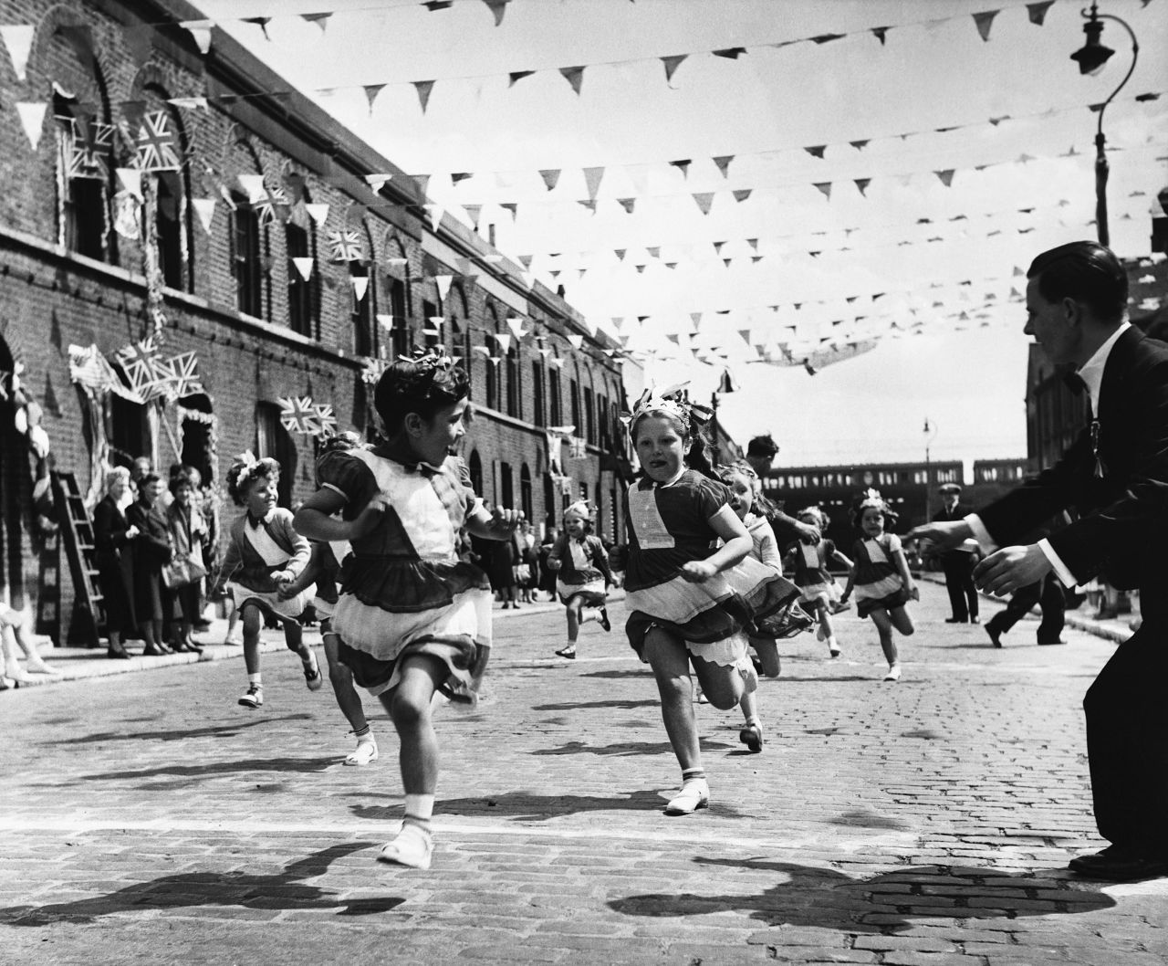 Children race at a coronation party in London's East End.