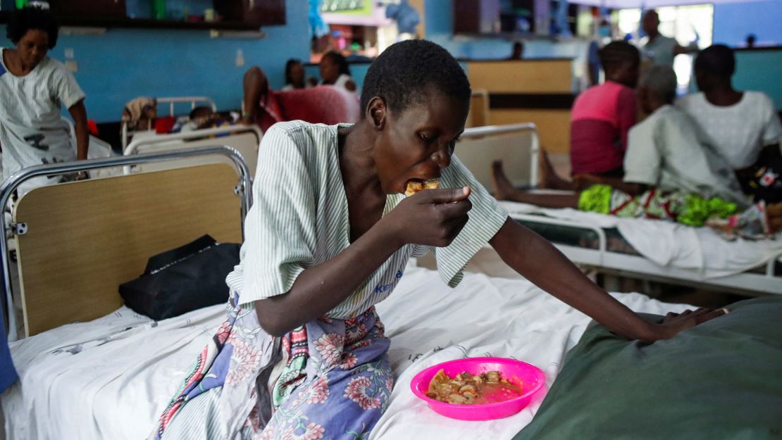 A survivor and a follower of Mackenzie's eats a meal inside a ward at the Malindi sub district hospital in April.