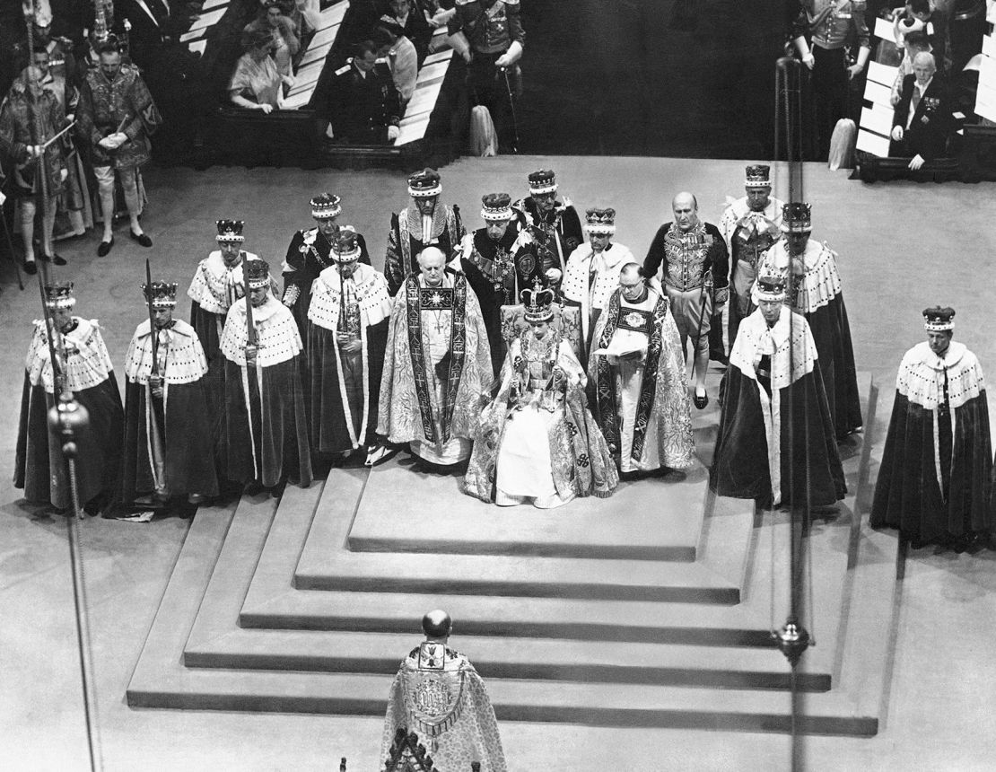 Surrounded by peers and churchmen, the newly crowned Queen Elizabeth II sits on the throne in Westminister Abbey on June 2, 1953.