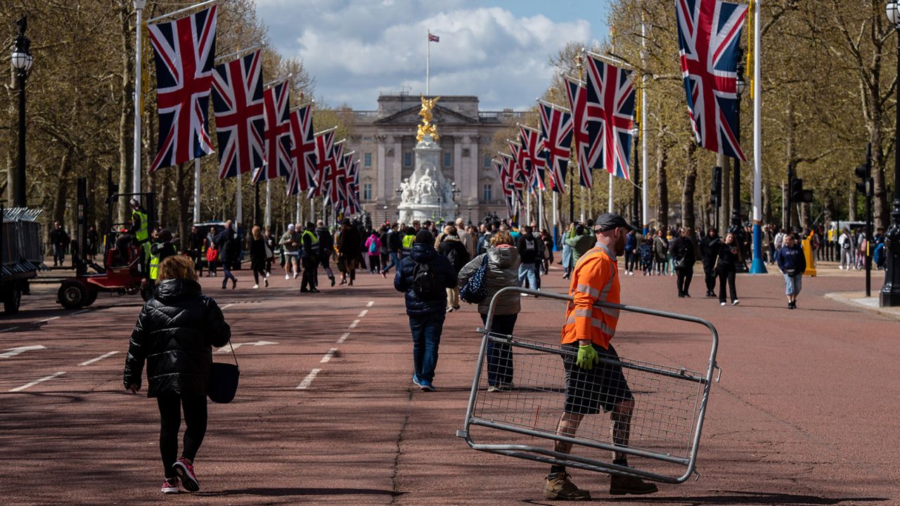 A worker carries a crowd control barrier on The Mall as preparations for the coronation begin.
