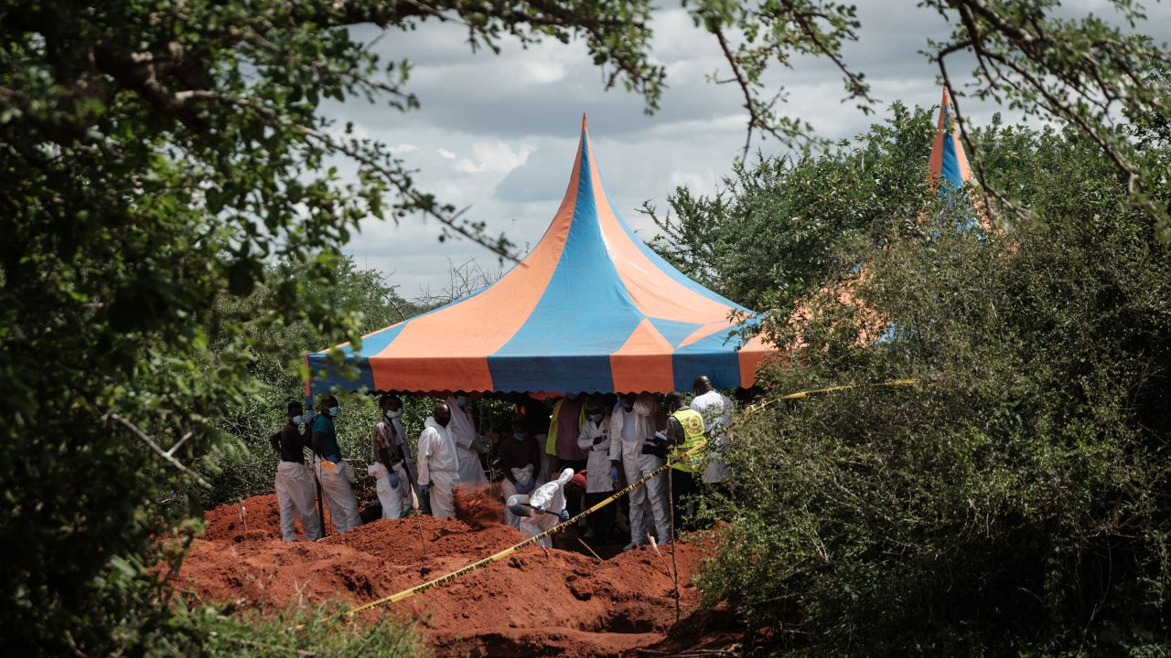 Workers take shelter while digging the ground to exume bodies from the mass-grave site in Shakahola, outside the coastal town of Malindi, on April 25, 2023.