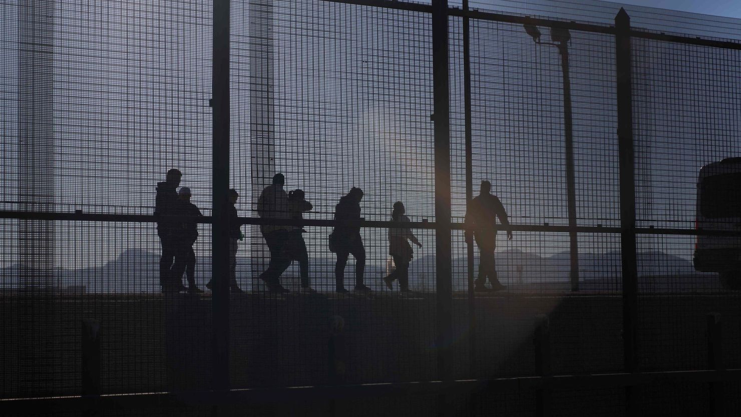 A US Border Patrol agent leads migrants who crossed into the US from Mexico to a van for transportation in El Paso, Texas, on December 21, 2022.