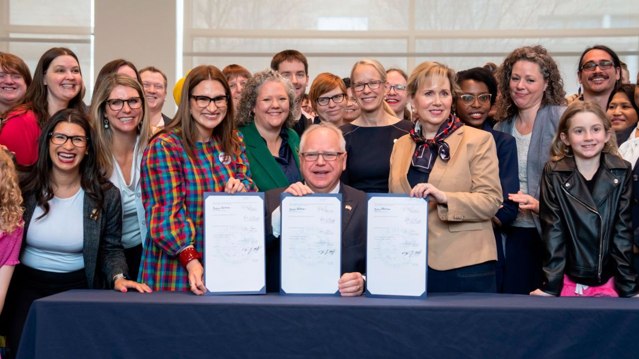 Minnesota Gov. Tim Walz poses with supporters after he signed three progressive priorities, a ban on conversion therapy for minors and vulnerable adults, and two bills that would make Minnesota a refuge for people traveling here for abortion and gender affirming care, on Thursday, April 27, 2023, in St. Paul.