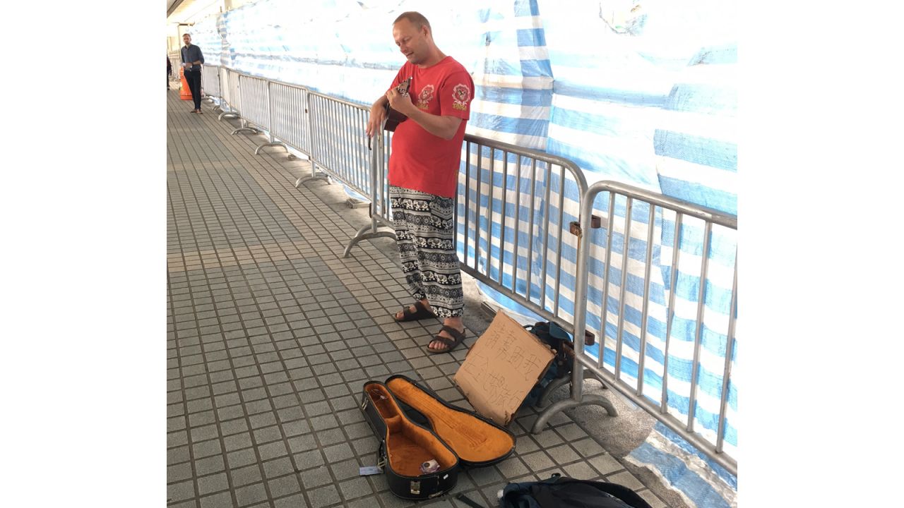 Pratt posing as a begpacker in a busy spot on Hong Kong island.