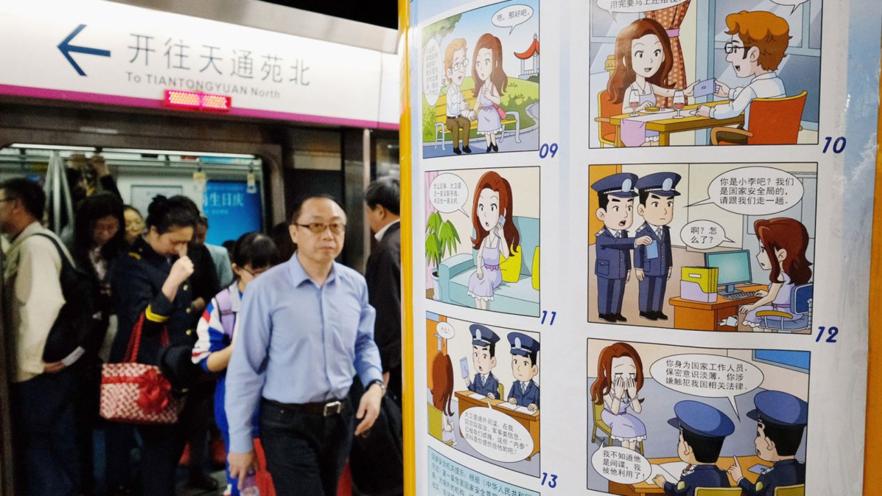 A comic strip poster warning of foreign spies is displayed at a subway station in Beijing on April 22, 2016