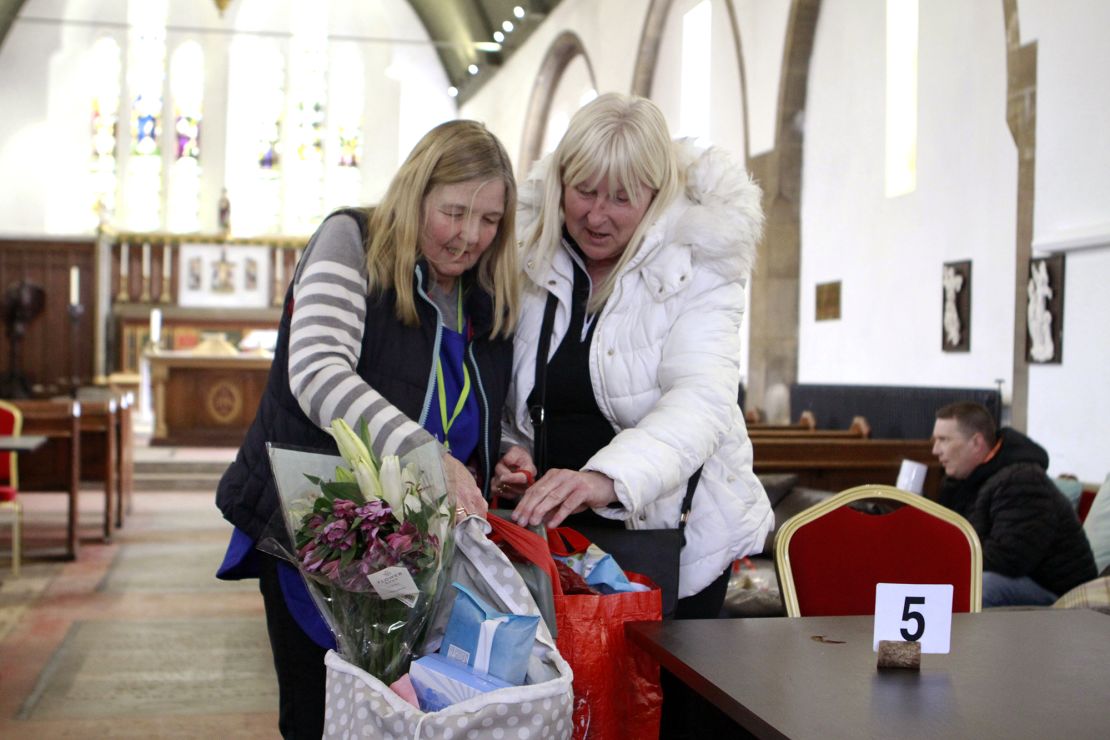 Liz Coopey, left, a volunteer at the Given Freely Freely Given food bank in Doncaster, helps local resident Angela Davis with her shopping bags.