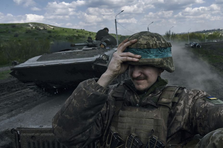 A Ukrainian soldier holds his helmet as he rides an armored vehicle in Bakhmut, Ukraine, on Wednesday, April 26.