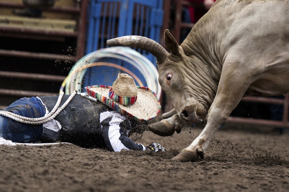 A bull-riding inmate falls to the ground during the Angola Prison Rodeo in Angola, Louisiana, on Sunday, April 23. The annual rodeo features inmates competing in events and selling crafts they make at the Louisiana State Penitentiary.