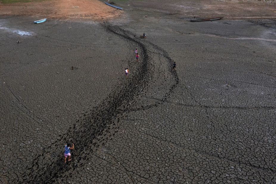 People in Panama walk over a dry part of Lake Alajuela on Friday, April 21. Because of severe drought, the lake is at its lowest levels in recent years.