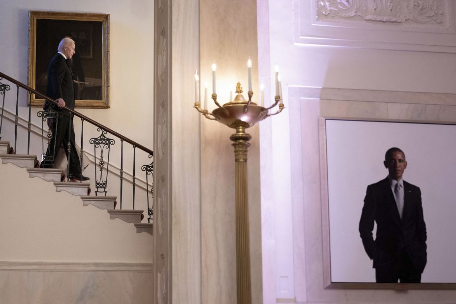 US President Joe Biden walks down White House stairs ahead of a state dinner for South Korean President Yoon Suk Yeol on Wednesday, April 26. At right is a portrait of former US President Barack Obama. Biden was Obama's vice president.