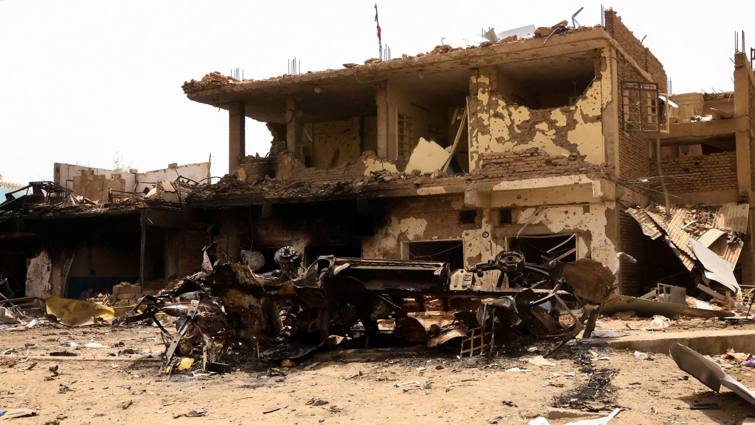 A damaged car and buildings at the central market during clashes between the paramilitary Rapid Support Forces and the army in Khartoum North, Sudan, on April 27, 2023. 