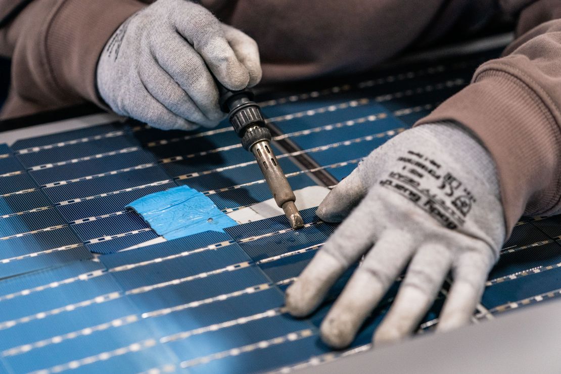 An employee solders damaged solar panel cells at the Hanwha QCells manufacturing facility in Dalton in October 2022.