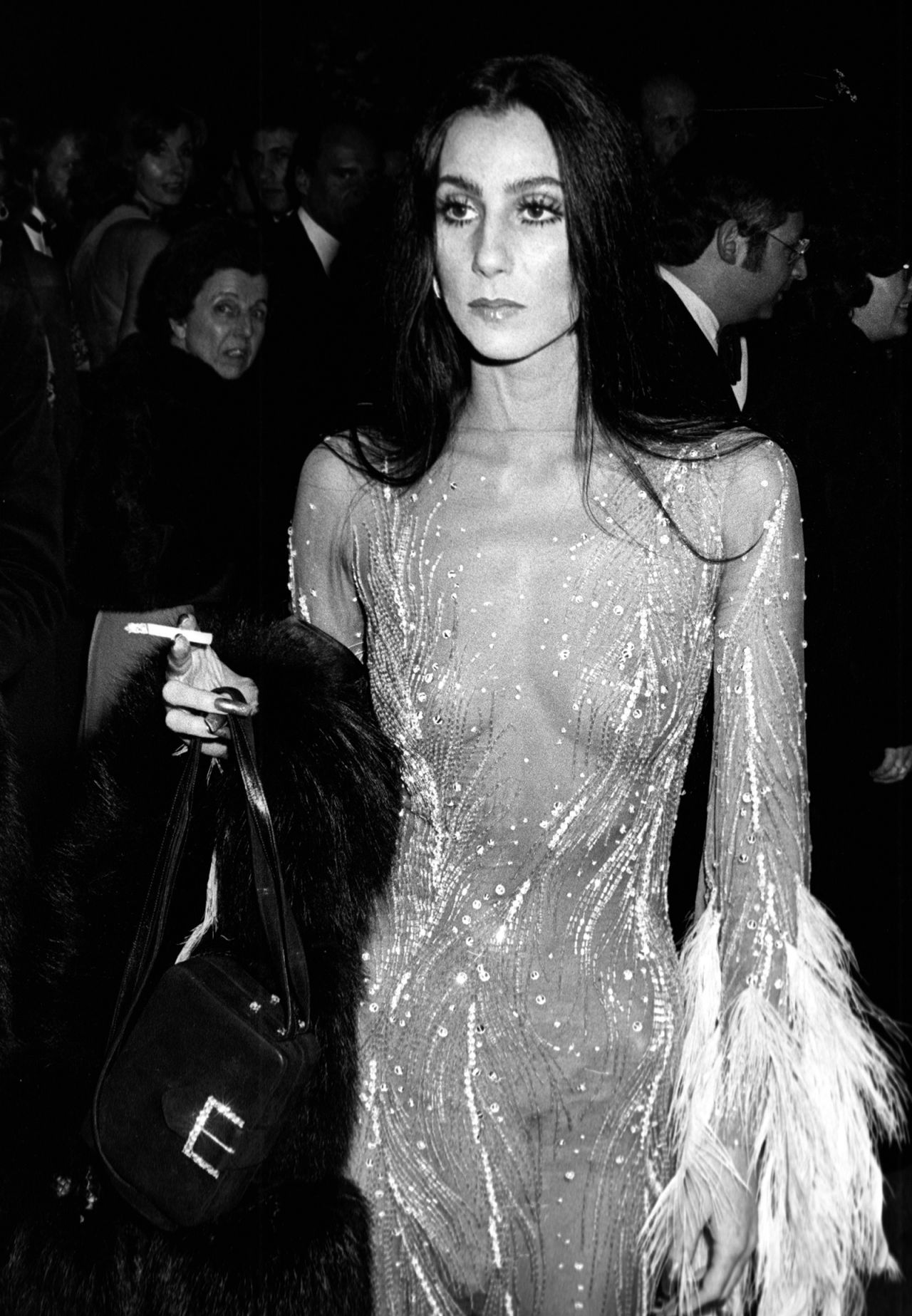 Cher smokes a cigarette during 1974's "Romantic and Glamorous Hollywood Design Exhibition" Met Gala.