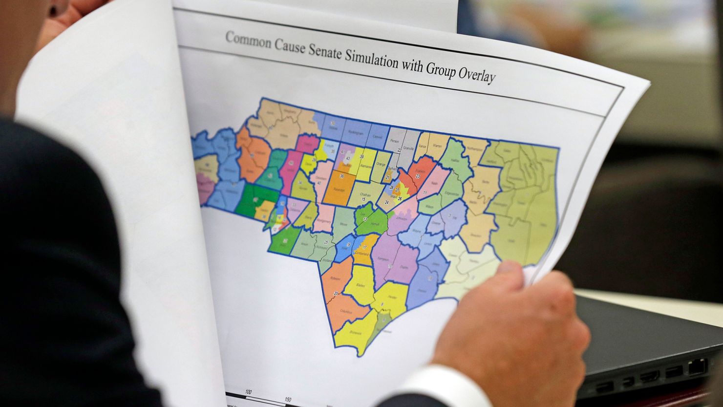 In this July 26, 2017, file photo, a lawmaker studies a district map during a joint select committee meeting on redistricting in Raleigh, North Carolina.