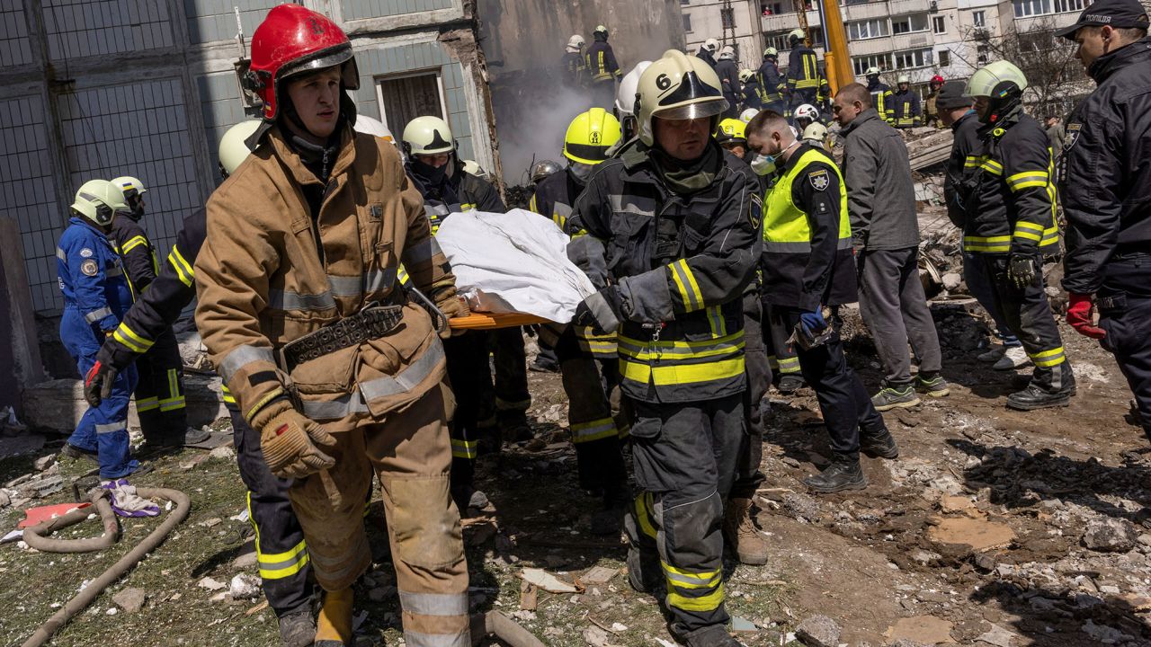 Rescuers carry a covered body as they work at the site of a heavily damaged residential building hit by a Russian missile in the town of Uman on Friday. 