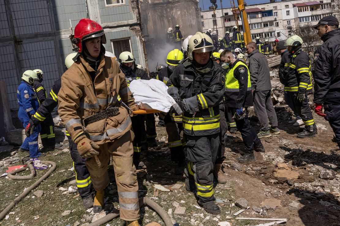 Rescuers carry a covered body as they work at the site of a heavily damaged residential building hit by a Russian missile in the town of Uman on Friday. 