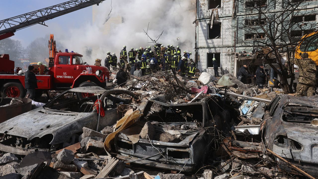   Autos incendiados yacen frente a un edificio residencial destruido en Uman. 
