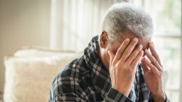 Senior African American man covering his face