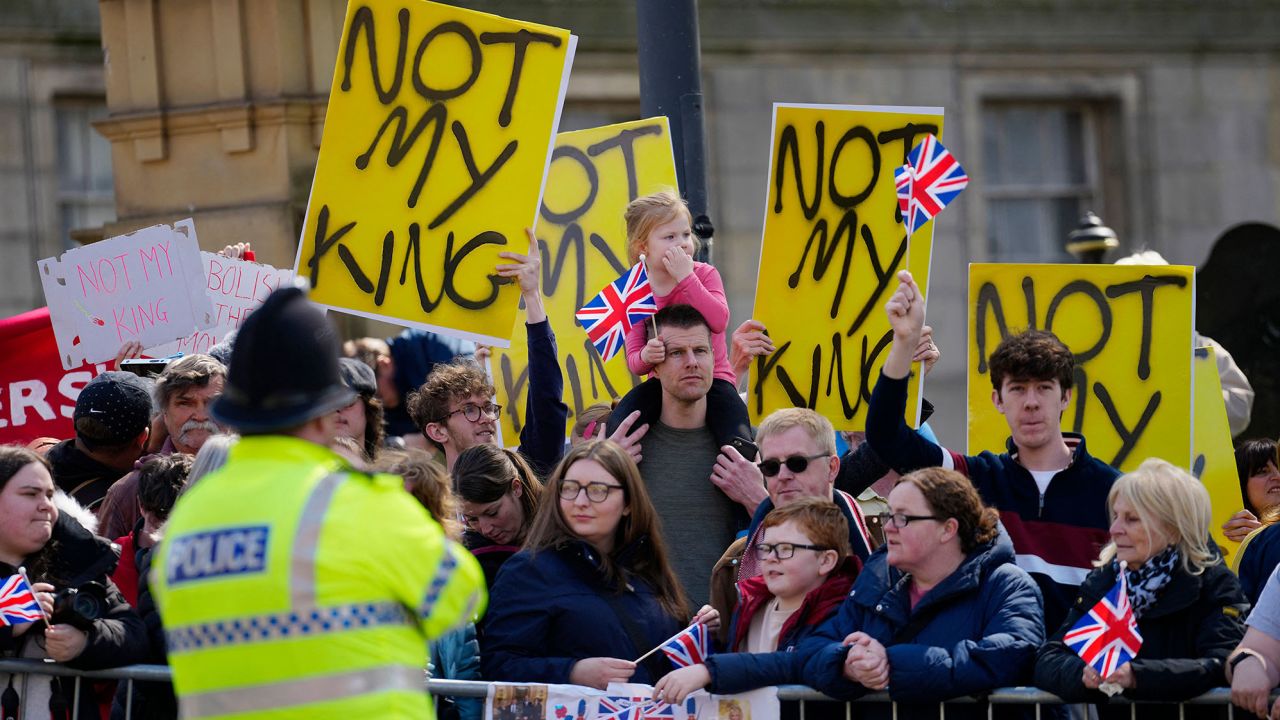 Protesters hold signs reading "Not My King" behind people who have gathered for the arrival of Britain's King Charles III and Britain's Queen Consort Camilla for a visit to the Liverpool Central Library on April 26, 2023 to officially mark the Library's twinning with Ukraine's first public Library, the Regional Scientific Library in Odessa. (Photo by Jon Super / POOL / AFP) (Photo by JON SUPER/POOL/AFP via Getty Images)