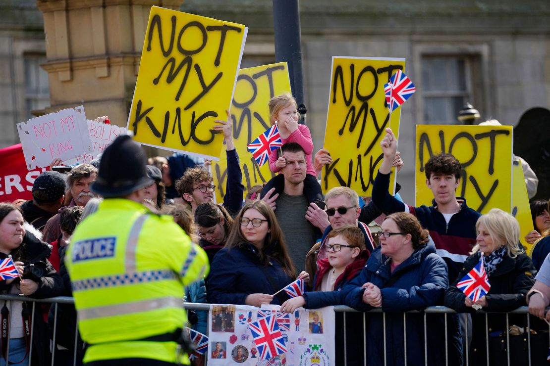 Protesters hold signs reading "Not My King" behind people who have gathered for the arrival of Britain's King Charles III and Britain's Queen Consort Camilla for a visit to the Liverpool Central Library on April 26, 2023 to officially mark the Library's twinning with Ukraine's first public Library, the Regional Scientific Library in Odessa. (Photo by Jon Super / POOL / AFP) (Photo by JON SUPER/POOL/AFP via Getty Images)