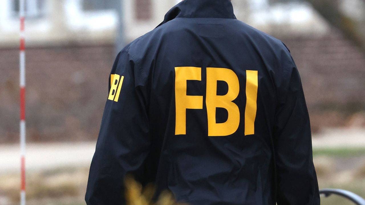 An FBI agent wearing a windbreaker is seen in February 2023.