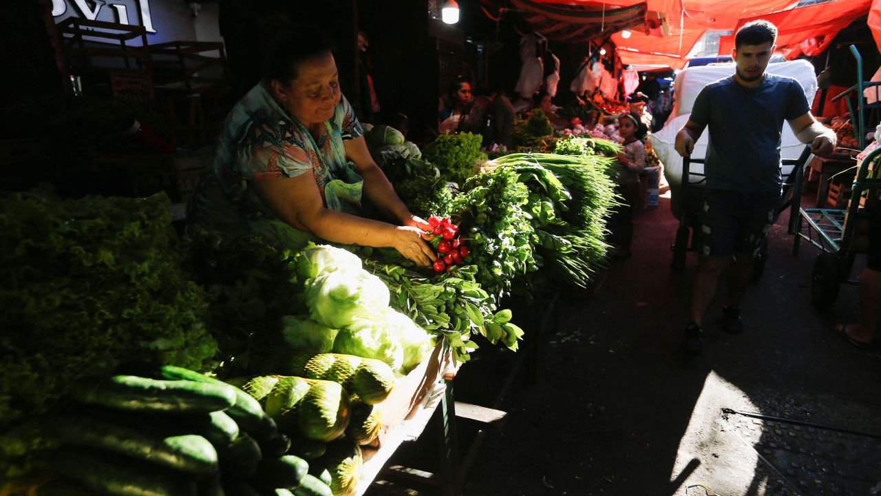 A woman arranges vegetables for sale at the Mercado 4 street market.