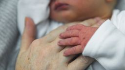 Newborn baby's hand on mother's hand - stock photo