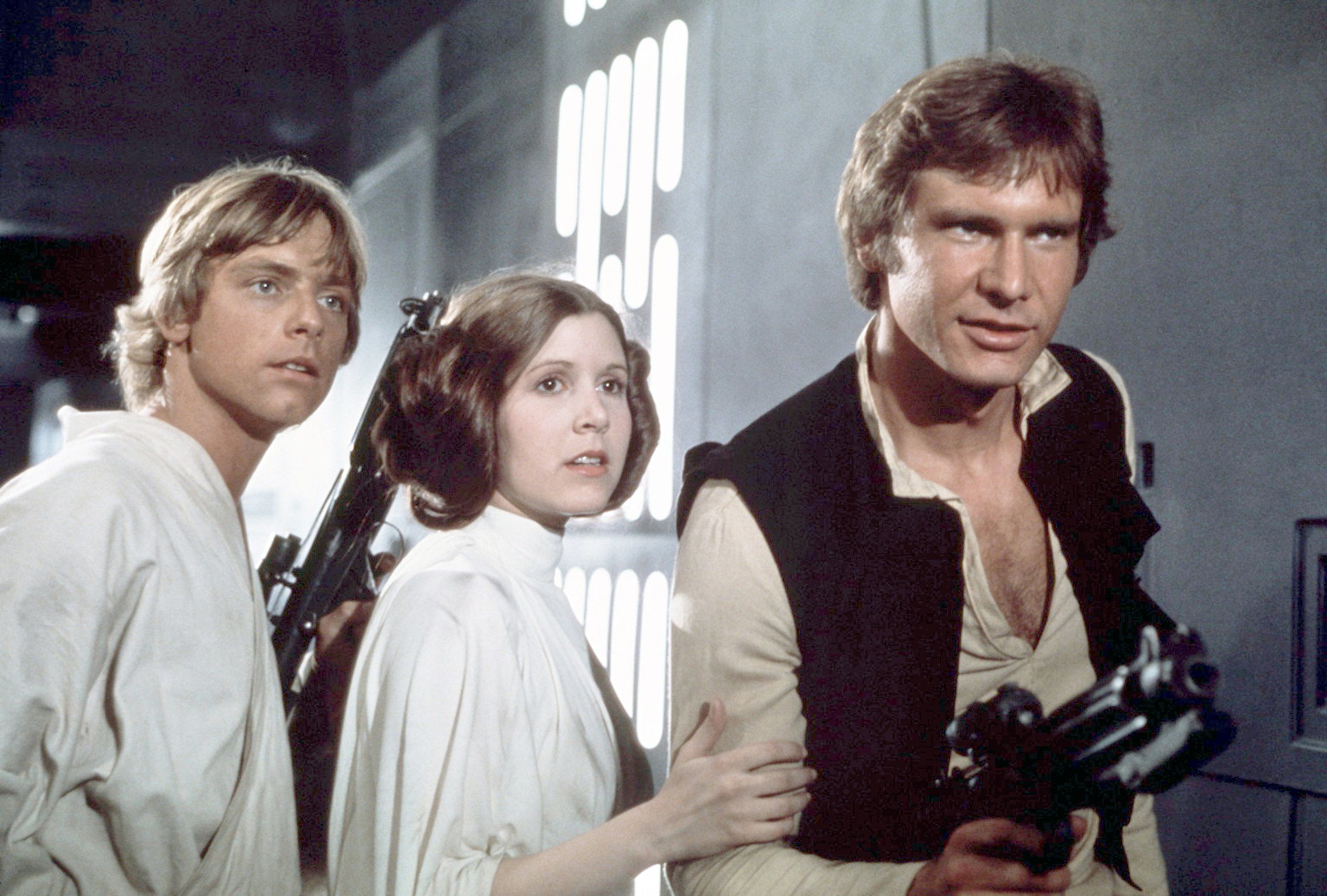 Fisher appears with Mark Hamill, left, and Harrison Ford on the set of the first "Star Wars" movie in 1977.