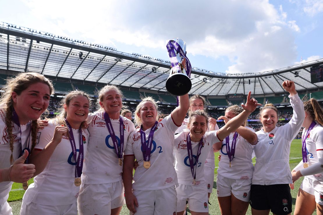 England's flanker and captain Marlie Packer celebrates with the trophy and teammates.