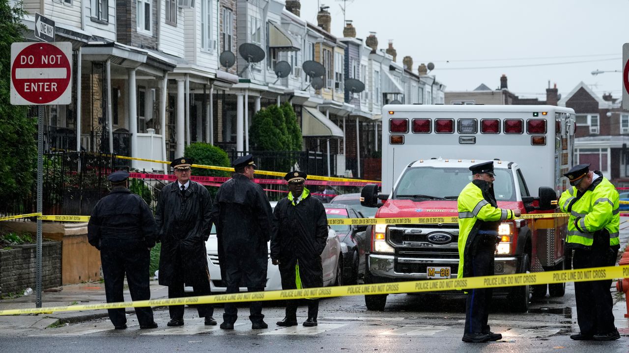 Law enforcement officers gather at the scene of a quadruple shooting in Philadelphia on Friday.