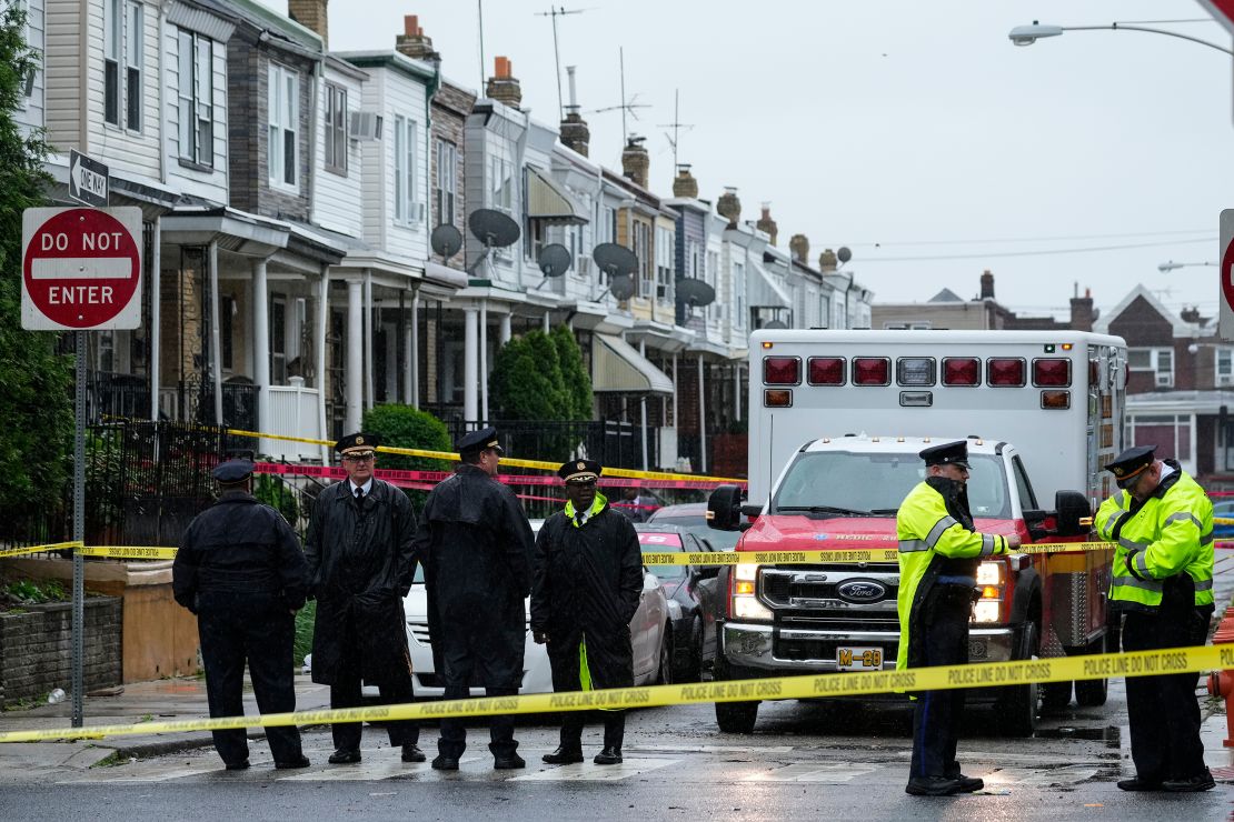 Law enforcement officers gather at the scene of a quadruple shooting in Philadelphia on Friday.