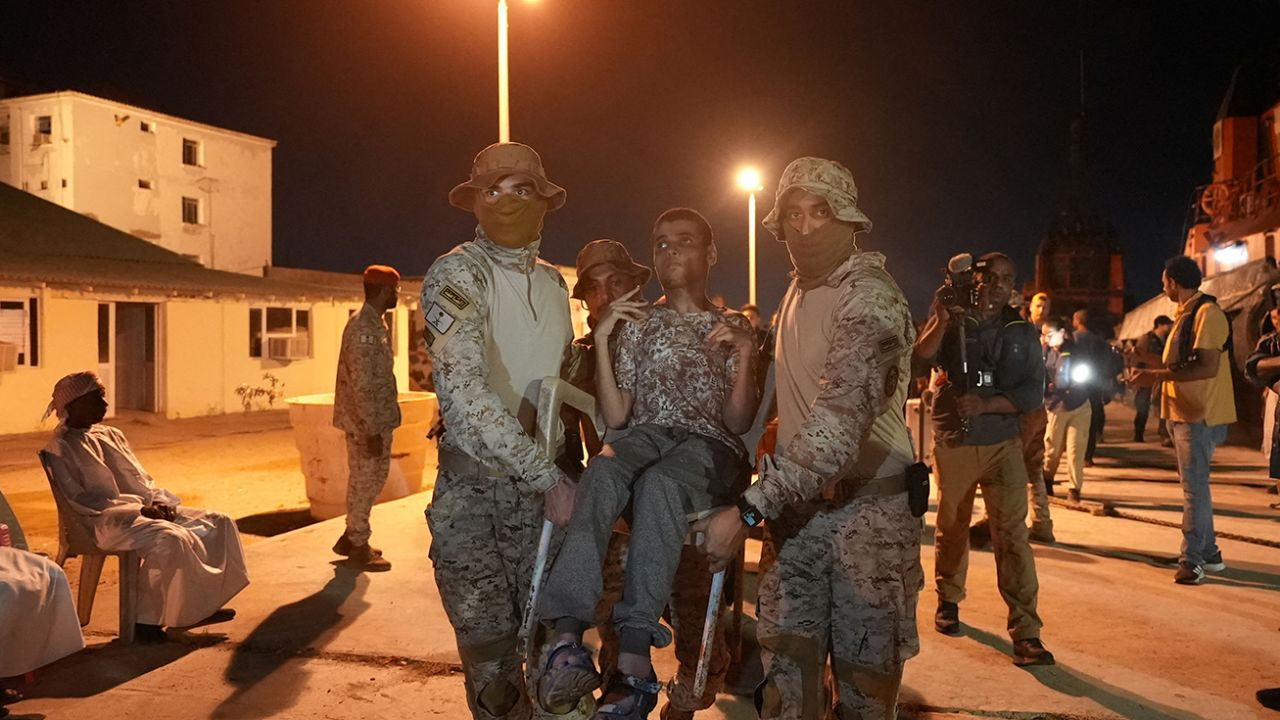 Saudi Royal Navy officials carry a disabled civilian to a Saudi Navy Ship, during his evacuation from Sudan to escape the conflict, Port Sudan, Sudan, April 30, 2023.