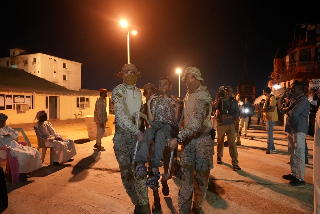 Saudi Royal Navy officials carry a disabled civilian to a Saudi Navy Ship, during his evacuation from Sudan to escape the conflict, Port Sudan, Sudan, April 30, 2023. 